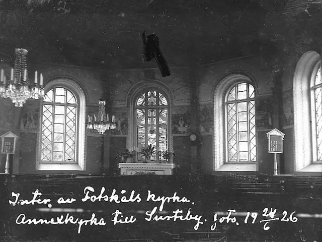 The image shows an old black and white photo of a church with chandeliers hanging from the ceiling,...