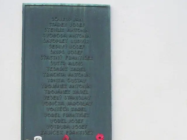 The image shows two plaques on the side of a building, each with text inscribed on them. The...