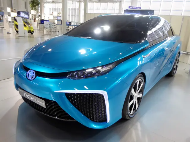 The image shows a blue Toyota FT-1 concept car on display at the Frankfurt Motor Show, surrounded...