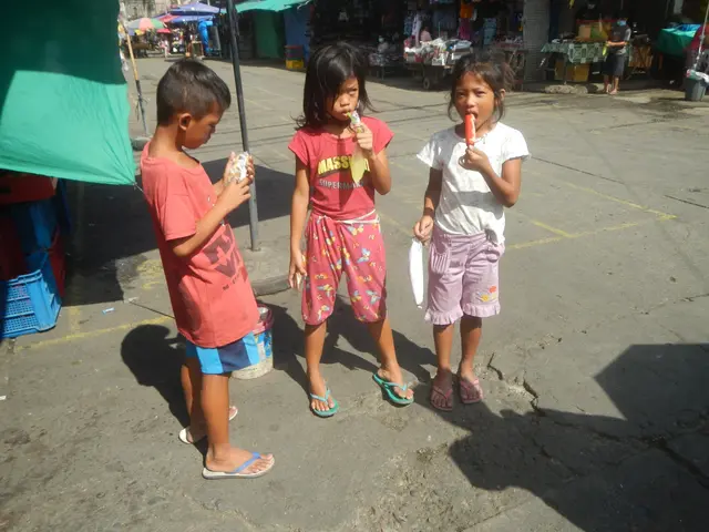 The image shows three children standing next to each other on a street, each holding an ice lolly...