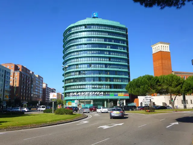 The image shows a bustling city street with vehicles driving on the road, grass on the ground,...