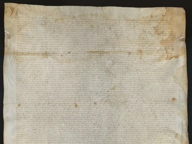 The image shows a piece of paper with writing on it against a dark background. The paper appears to...