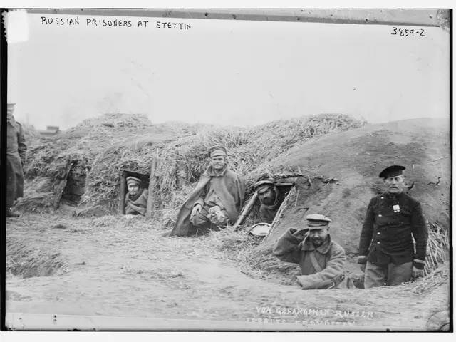 The image shows a group of Russian prisoners at Stettin, standing and sitting in a grassy area with...