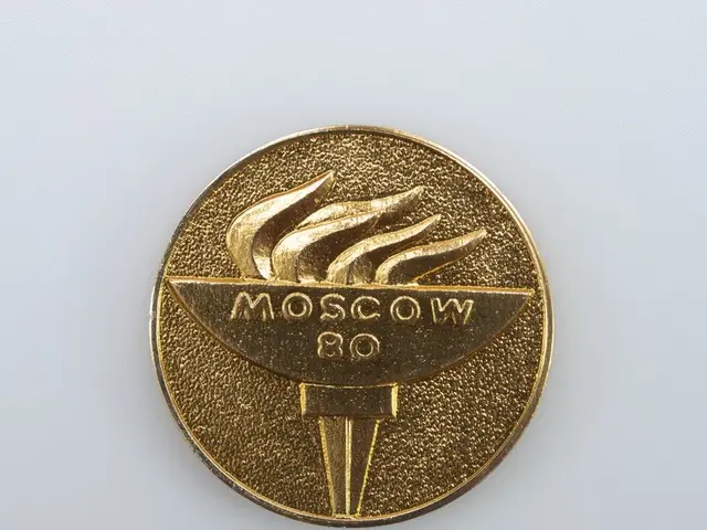 The image shows a gold medal with the words "Moscow 80" inscribed on it, set against a white...