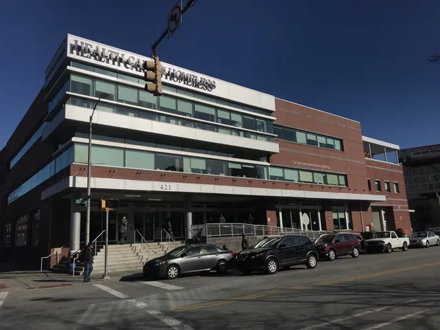 The image shows a large building with cars parked in front of it, surrounded by street poles,...