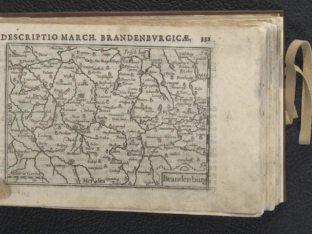 The image shows an open book with a map of Brandenburg on it, placed on a black surface. The map is...