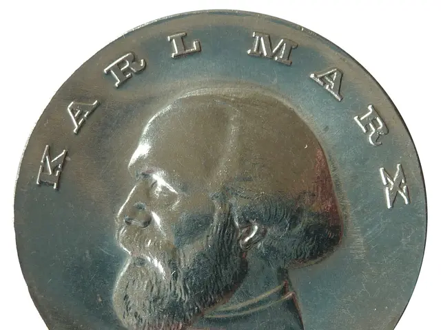 The image shows a silver medal with a portrait of Karl Marx on it against a white background.