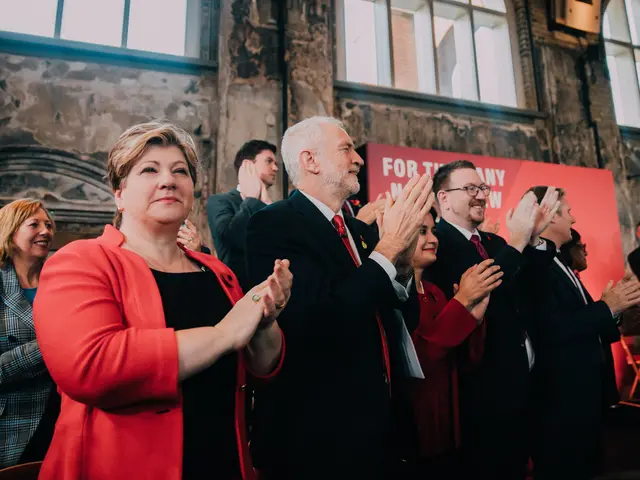 The image shows a group of people standing in front of a crowd, clapping their hands in...