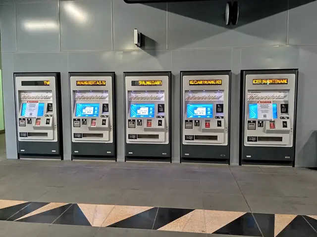The image shows a row of vending machines sitting on top of a tiled floor, with a wall in the...