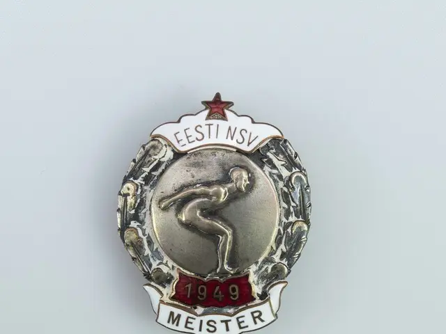 The image shows a silver badge with a red star on it, which is the emblem of the German Olympic...