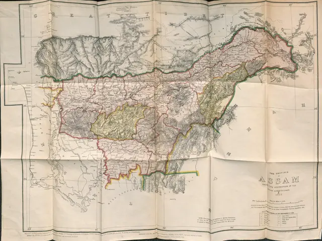 The image shows an old map of the provinces of Assam, India, with text on the paper and a black...