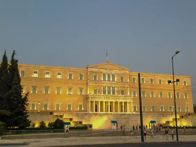 The image shows the Greek Parliament building in Athens, Greece. It is a large building with...