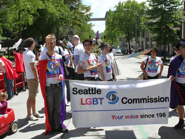 The image shows a group of people walking down a street, holding a banner with the words "Seattle...