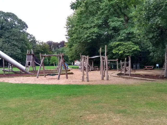 The image shows a playground with wooden poles, a slide, a bench, a trash bin/can, grass, a group...