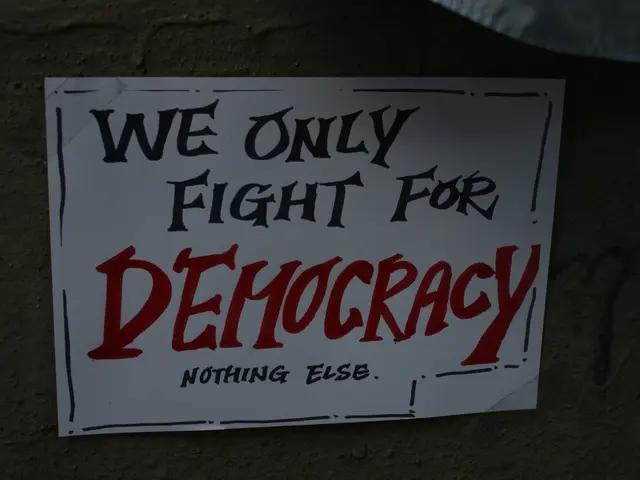 The image shows a white paper with the words "We Only Fight for Democracy" written on it, attached...