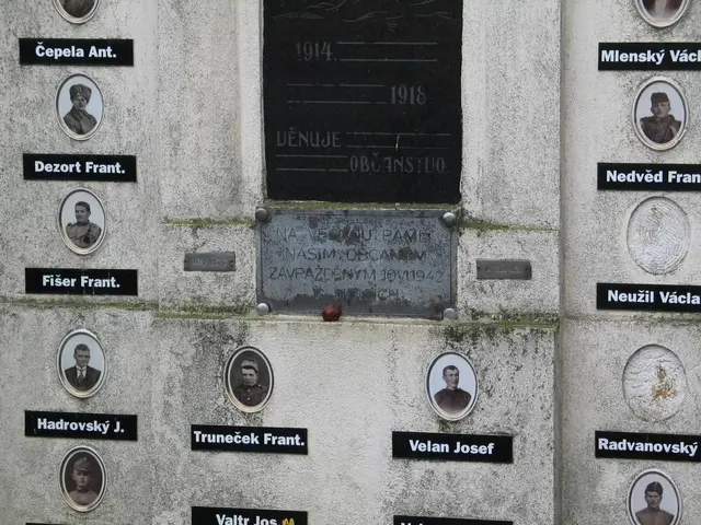 The image shows a wall with a plaque on it, featuring pictures of people and text. The plaque is...