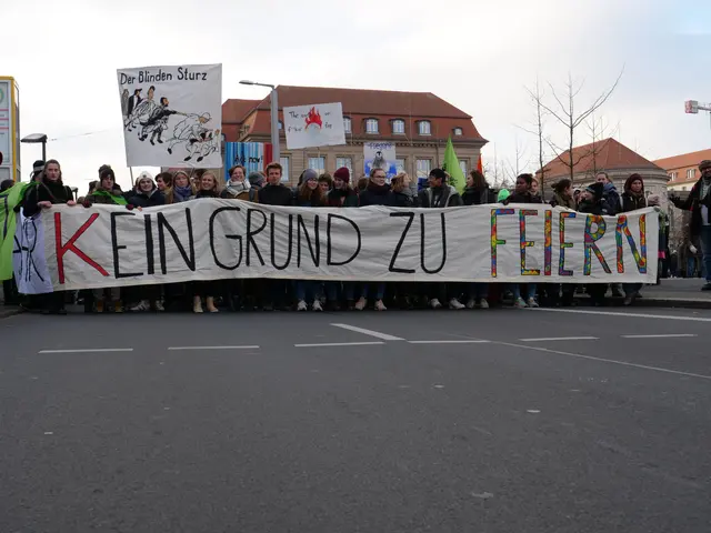 The image shows a group of people standing on the road, holding a banner that reads "Kein Grund zu...
