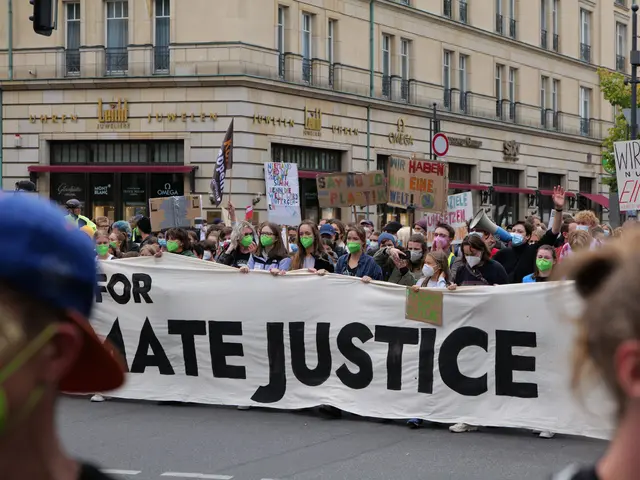 The image shows a group of people wearing masks and holding a banner that reads "For Hate Justice"...
