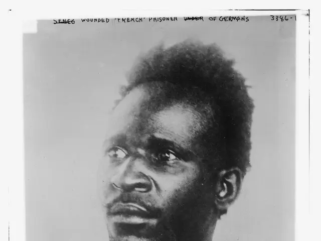 The image shows a black and white photo of a man with a serious expression on his face. At the top...