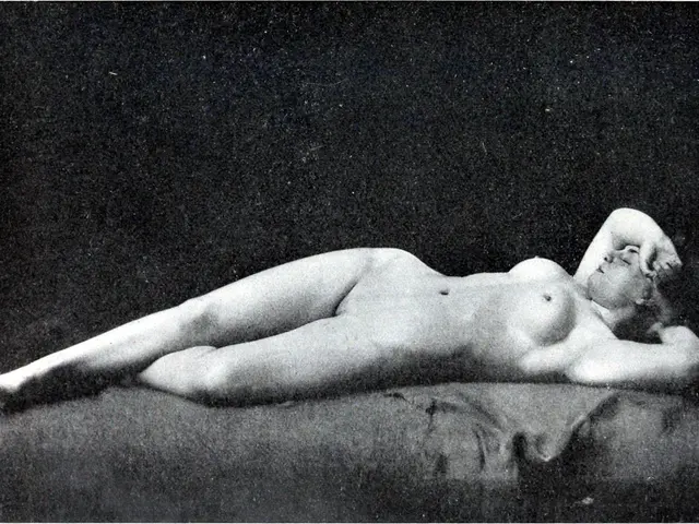 The image shows a black and white photo of a nude woman laying on a bed, with a dark background and...