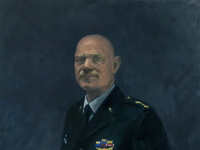 The image shows a commissioned military officer in a black uniform, holding a hat in his hand. He...