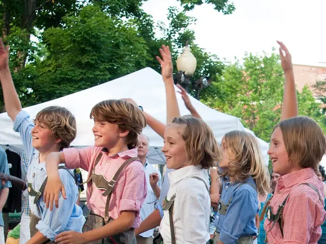The image shows a group of children in traditional Bavarian clothing dancing on the street,...