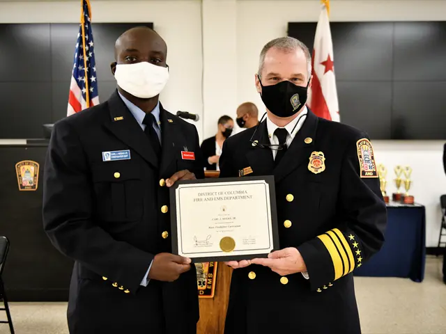 The image shows two men in uniform standing next to each other, both wearing masks and holding a...
