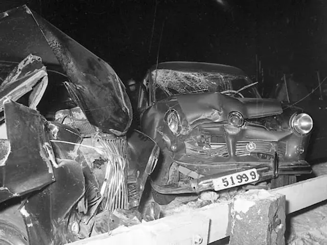 The image shows a black and white photo of a car that has been involved in a crash, with its hood...
