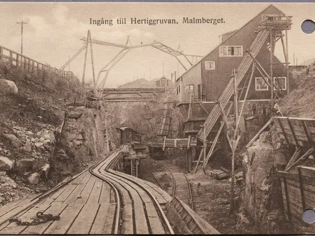 The image shows an old black and white photo of a train going through a tunnel, with railway...