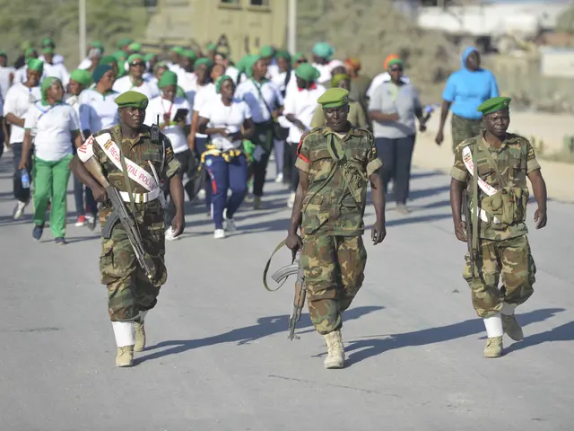 The image shows a group of people walking down a street, some of them wearing caps and holding...