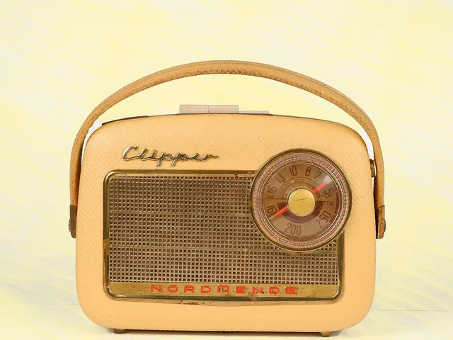The image shows an old fashioned cream-colored Nordmende Clipper DAB+/FM radio sitting on top of a...