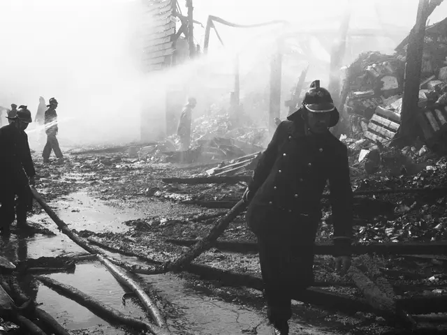 The image shows a group of firefighters walking through the rubble of a destroyed building, wearing...