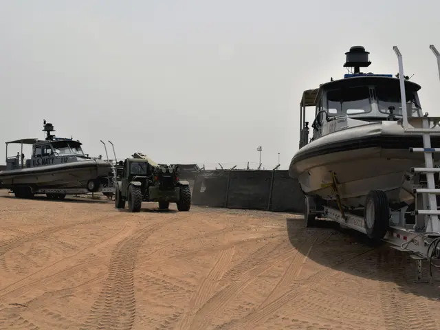 The image shows a boat being loaded onto a trailer in the sand, with a vehicle and a wheel in the...