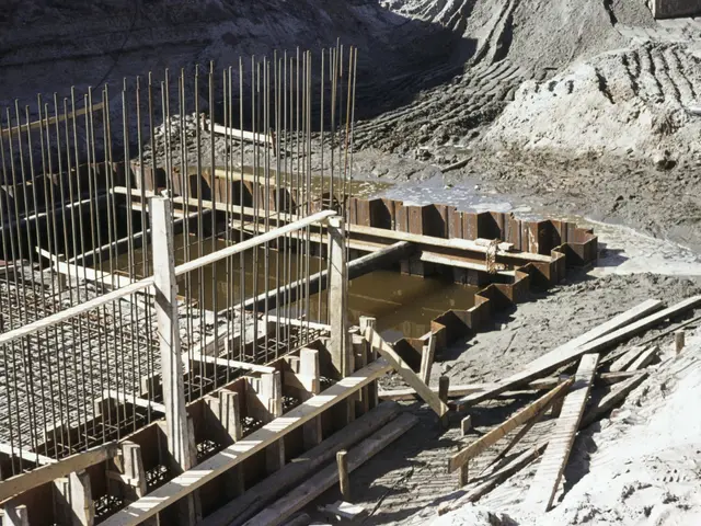 The image shows a construction site with a large pile of dirt and wooden sticks, as well as iron...