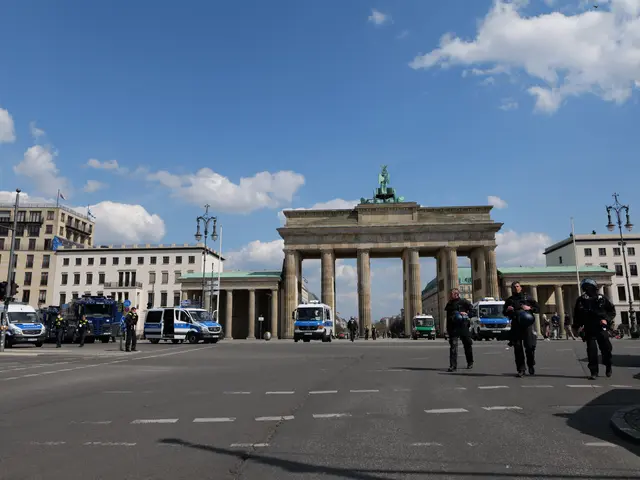 The image shows a group of police officers standing in front of the Brandenburg Gate in Berlin,...