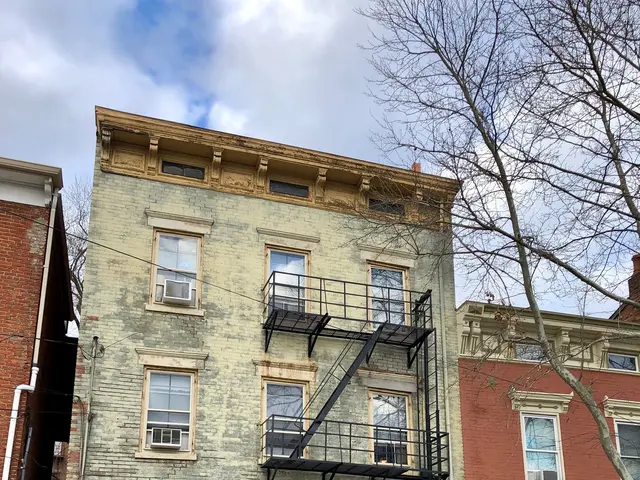 The image shows a building with windows, doors, railings, steps and other objects, as well as a car...