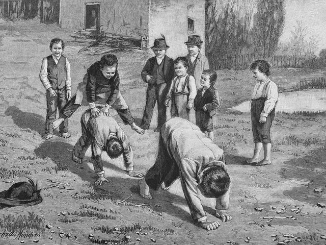 The image shows a group of children playing with each other in a field. In the center of the image,...