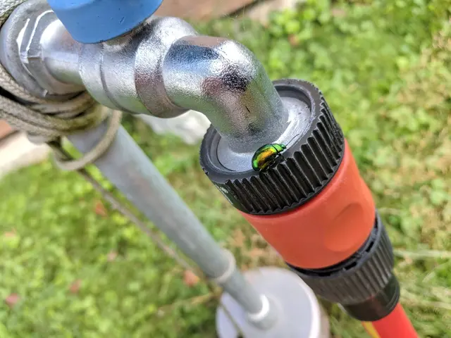 The image shows a close up of a pipe with a hose attached to it, connected to a pipe holder with a...