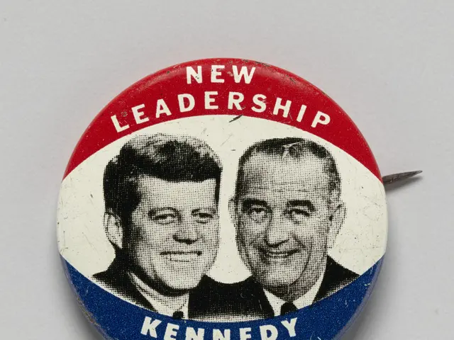 The image shows a white surface with a pinback button featuring two pictures of Kennedy and...