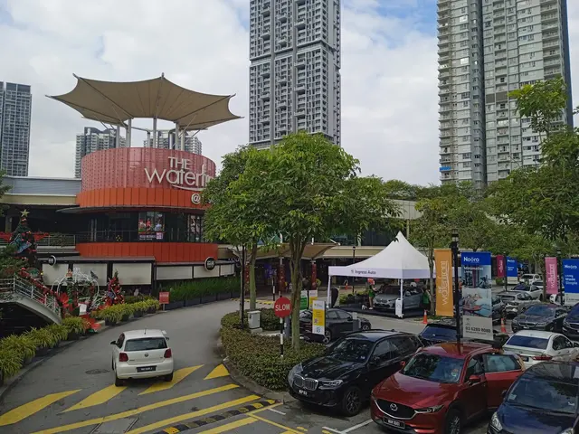 The image shows a bustling city street with cars parked in front of tall buildings. There are...