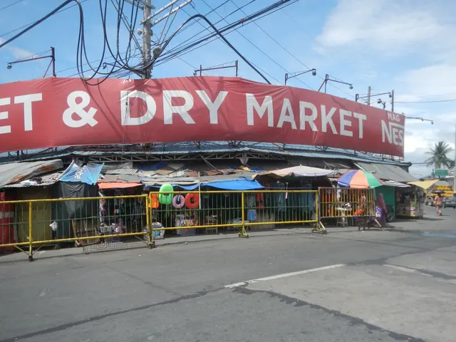 The image shows a wet and dry market in the Philippines, with a road in the foreground, a few...