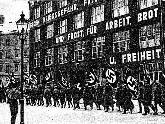 The image shows a group of people marching down a street in front of a building, holding flags and...