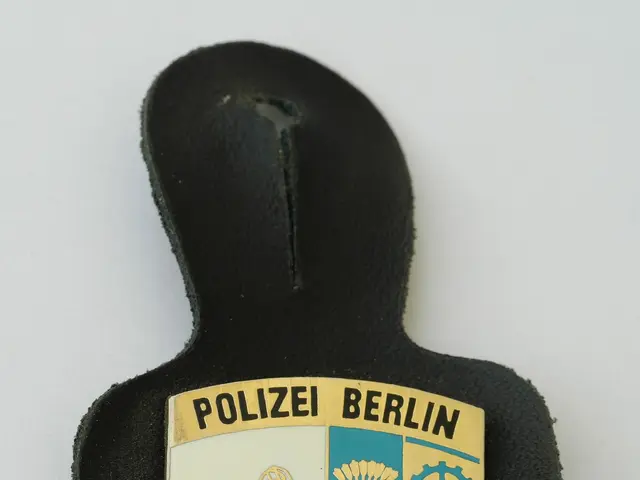 The image shows a police badge with the words "Police Berlin" on it, placed on a surface. The badge...