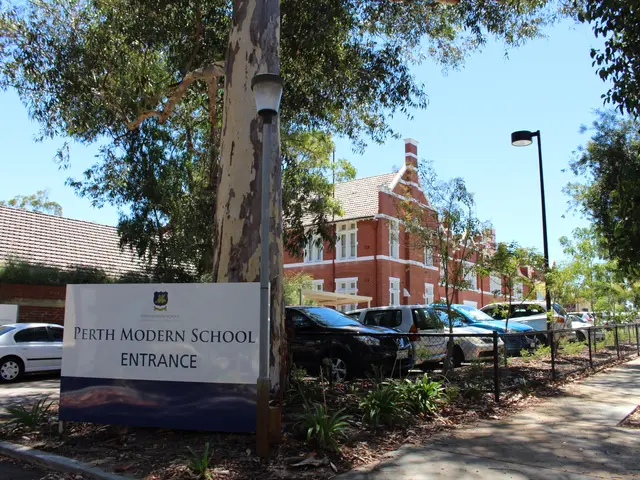 The image shows the entrance to Perth Modern School, with a board with text on it, a group of...