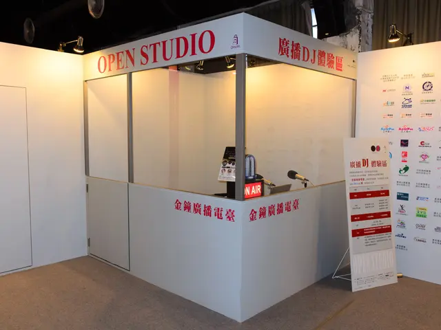 The image shows an open studio booth with a sign that says "Open Studio" on it. There is a table...