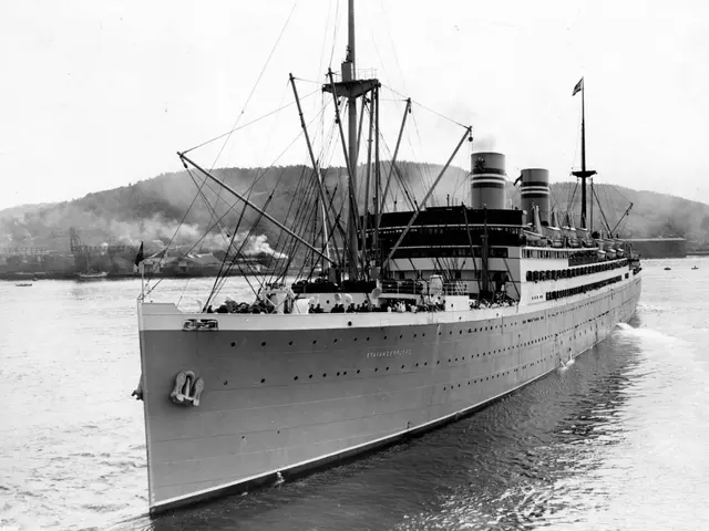 The image shows a large boat, the sternwheeler, sailing on top of a body of water with a few other...