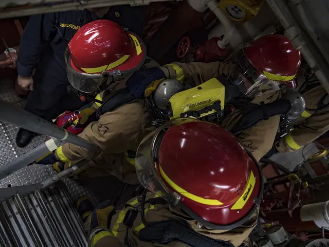 The image shows a group of firefighters wearing helmets and protective gear, working on a fire...