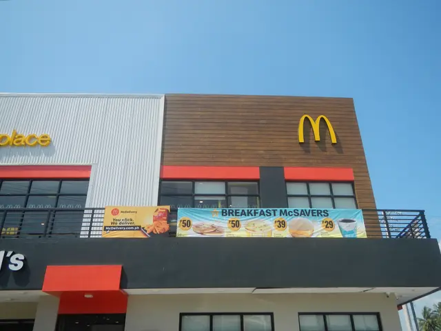 The image shows a McDonald's restaurant with a sign on the side of it, surrounded by trees and a...