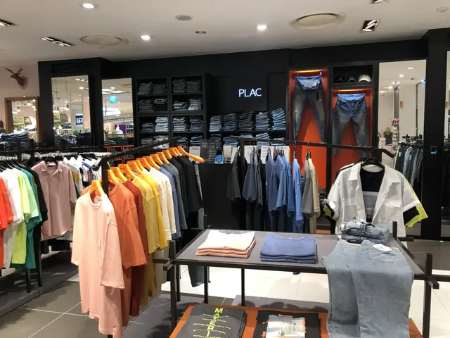 The image shows a clothing store filled with lots of clothes on display, including t-shirts, jeans,...