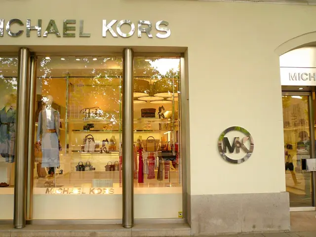 The image shows a Michael Kors store in New York City, with glass walls and doors, mannequins...